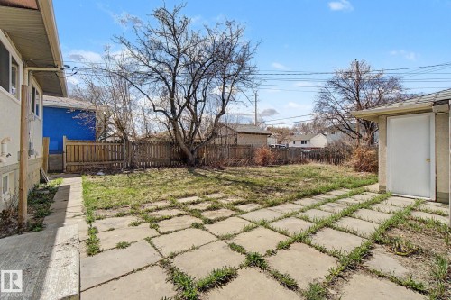 Expansive backyard featuring a concrete paver patio, a perimeter wood fence, and mature trees - 6048 105B Street, Edmonton, AB - Outdoor