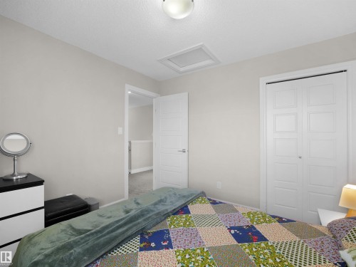 Neutral-toned room featuring a white ceiling and walls, two panel doors, and a ceiling-mounted light fixture - 3247 15 Avenue Nw, Edmonton, AB 