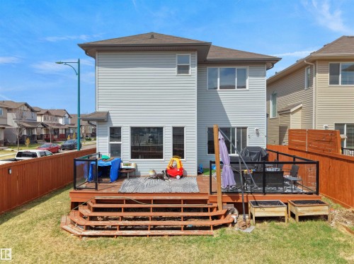 Rear exterior featuring light-colored horizontal siding and a multi-level wooden deck - 3247 15 Avenue Nw, Edmonton, AB 