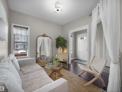 Living area featuring dark wood-finish flooring, light grey wall paint, and a semi-flush mount ceiling light - 3247 15 Avenue Nw, Edmonton, AB 