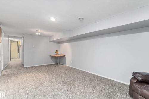 Spacious room featuring light gray walls, textured gray carpeting, and recessed lighting - 6734 36A Avenue, Edmonton, AB 