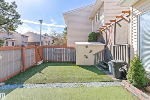 Fenced backyard featuring artificial turf, a gravel border, and a raised wooden deck with exterior stairs - 6734 36A Avenue, Edmonton, AB 