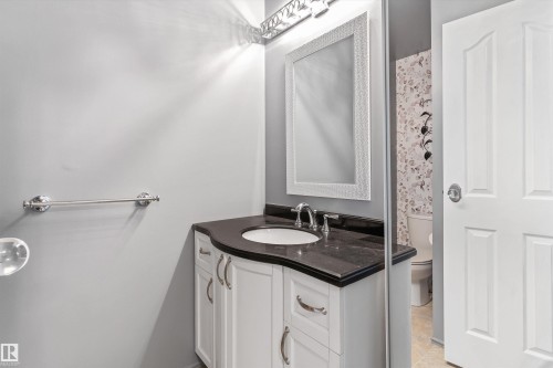 Vanity with integrated sink, dark countertop, and white cabinetry - 6734 36A Avenue, Edmonton, AB 