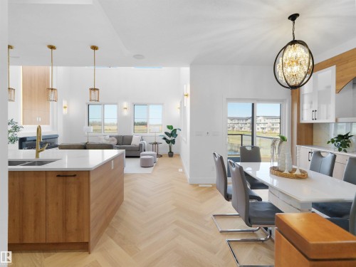 Spacious open-concept interior featuring light wood-finish flooring in a herringbone pattern - 209 Crystal Creek Dr Nw, Leduc, AB - Indoor