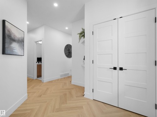 Hallway featuring light wood-finish flooring in a herringbone pattern, recessed lighting, and white walls - 209 Crystal Creek Dr Nw, Leduc, AB - Indoor Photo Showing Other Room