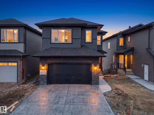Two-story home with a dark gray exterior and contrasting light gray siding accents - 209 Crystal Creek Dr Nw, Leduc, AB - Outdoor