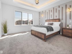 Room featuring a tray ceiling with recessed lighting, a decorative accent wall, and light gray carpeting - 