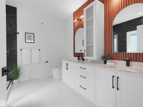 Dual vanity with white cabinetry and integrated sinks, accented by matte black hardware and faucets - 209 Crystal Creek Dr Nw, Leduc, AB - Indoor Photo Showing Bathroom