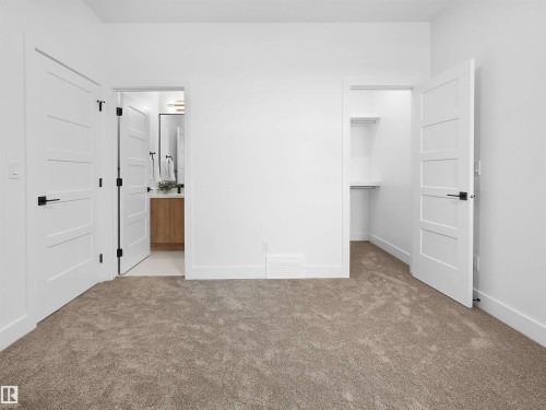 Carpeted interior space featuring white walls and white trim - 209 Crystal Creek Dr Nw, Leduc, AB - Indoor Photo Showing Other Room