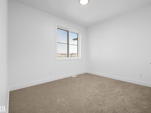 Neutral toned carpeted room with white walls and trim - 209 Crystal Creek Dr Nw, Leduc, AB - Indoor Photo Showing Other Room
