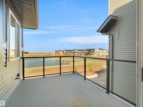 Private balcony with concrete flooring, glass panel railings, and metal framing - 209 Crystal Creek Dr Nw, Leduc, AB - Outdoor With View With Exterior