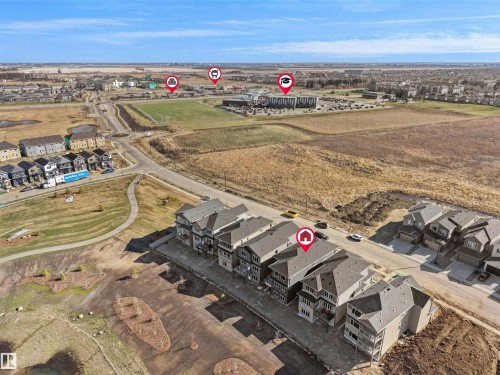 Aerial perspective showcasing a residential development with multiple detached and attached homes - 209 Crystal Creek Dr Nw, Leduc, AB - Outdoor With View