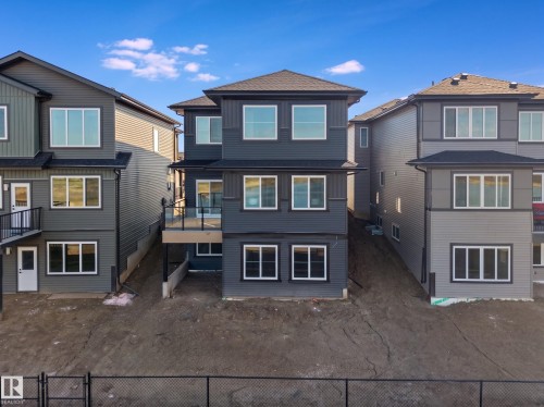 Modern three-story residence featuring dark gray siding and white trim - 209 Crystal Creek Dr Nw, Leduc, AB - Outdoor With Facade