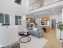 Two-story living area with high ceilings, large windows, and herringbone wood-finish flooring - 209 Crystal Creek Dr Nw, Leduc, AB  - Indoor Photo Showing Living Room 