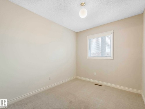 Neutral-toned room featuring a single window with blinds, light beige carpeting, and white baseboards - 4011 104 Street, Edmonton, AB - Indoor Photo Showing Other Room