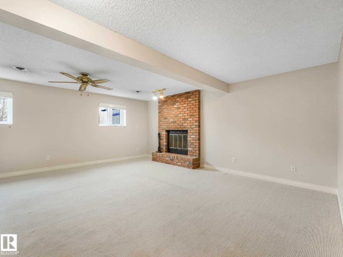 Expansive room featuring light-toned carpeting and neutral wall tones - 4011 104 Street, Edmonton, AB - Indoor With Fireplace