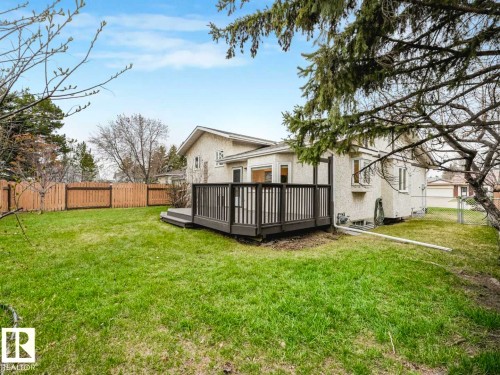 Expansive green lawn featuring a multi-level composite deck with dark railings - 4011 104 Street, Edmonton, AB - Outdoor With Deck Patio Veranda