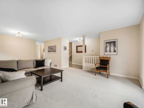 Carpeted living area with light-toned walls and a ceiling-mounted light fixture - 4011 104 Street, Edmonton, AB - Indoor Photo Showing Living Room
