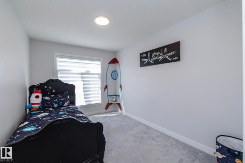 Carpeted room featuring a single window with horizontal blinds, recessed ceiling lighting, and light-toned walls - 1448 Darby Green Green, Edmonton, AB - Indoor