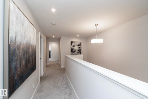 Upper-level hallway with gray carpeting, recessed lighting, and a contemporary drum pendant light fixture - 1448 Darby Green Green, Edmonton, AB - Indoor Photo Showing Other Room