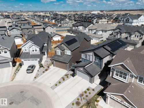 Residential development featuring multiple modern homes, each with individual driveways and attached garages - 1448 Darby Green Green, Edmonton, AB - Outdoor
