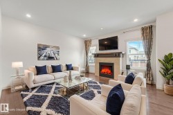 Living area featuring recessed lighting, dark wood-finish flooring, and a fireplace with a stone surround and wood mantel - 