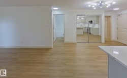 Open-concept living area featuring wood-finish flooring, recessed lighting, and a modern sputnik-style light fixture - 