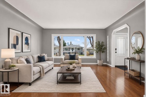 Bright living space featuring warm wood-finish flooring - 10409 83 Street, Edmonton, AB - Indoor Photo Showing Living Room