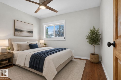 Bedroom featuring wood-finish flooring, a contemporary ceiling fan, and a large window with white trim - 10409 83 Street, Edmonton, AB - Indoor Photo Showing Bedroom