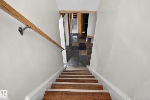 Staircase featuring wood treads with white risers and a natural wood handrail - 10409 83 Street, Edmonton, AB - Indoor Photo Showing Other Room