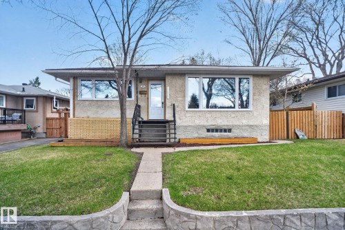 Stucco-finished home featuring a light-colored exterior and a contrasting dark roofline - 10409 83 Street, Edmonton, AB - Outdoor
