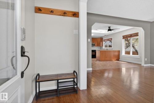 Hardwood-style flooring extends from the entry into the primary living area - 10409 83 Street, Edmonton, AB - Indoor Photo Showing Other Room