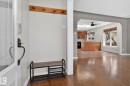 Hardwood-style flooring extends from the entry into the primary living area - 10409 83 Street, Edmonton, AB  - Indoor Photo Showing Other Room 