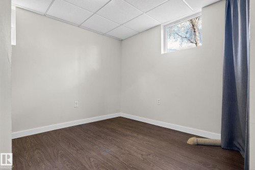 Room featuring wood-finish flooring, light-toned walls, and a drop ceiling - 10409 83 Street, Edmonton, AB - Indoor Photo Showing Other Room