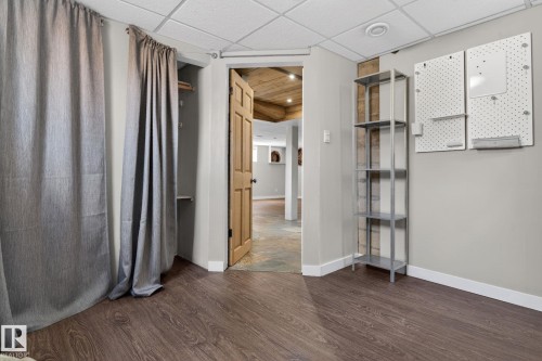 Interior room featuring wood-finish flooring, light gray wall paint, and white baseboards - 10409 83 Street, Edmonton, AB - Indoor Photo Showing Other Room