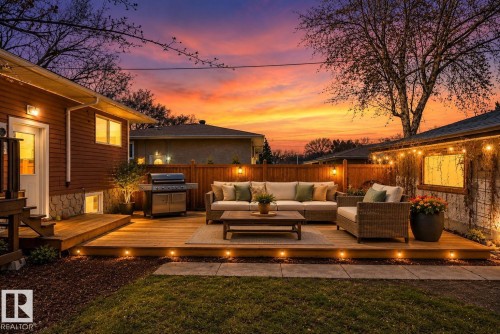 Expansive outdoor deck featuring integrated ground-level lighting, a built-in privacy fence, and string lighting - 10409 83 Street, Edmonton, AB - Outdoor With Deck Patio Veranda