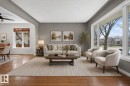 Living area featuring expansive picture windows, hardwood flooring, a recessed ceiling, and an arched entryway - 10409 83 Street, Edmonton, AB  - Indoor Photo Showing Living Room 