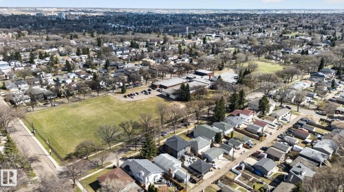 Aerial perspective showcasing a residential neighborhood with a prominent community green space and adjacent school building - 10409 83 Street, Edmonton, AB - Outdoor With View