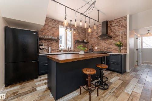 Beautifully updated kitchen with quartz counters, gas stove, and industrial-style lighting - 10956 81 Avenue, Edmonton, AB - Indoor Photo Showing Kitchen