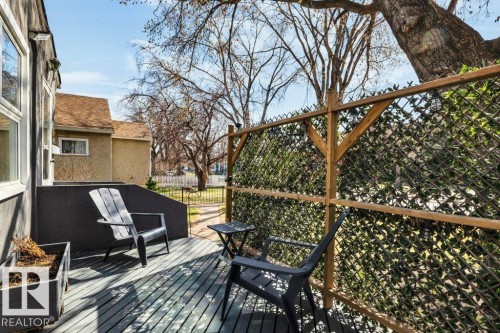 Outdoor deck with painted wood flooring and a privacy lattice fence featuring faux greenery - 11445 68 Street, Edmonton, AB - Outdoor With Deck Patio Veranda