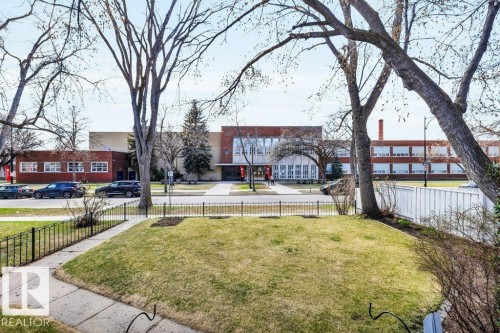 Expansive green lawn and concrete pathway framed by a black metal fence - 11445 68 Street, Edmonton, AB - Outdoor