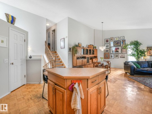 Kitchen island with light wood cabinetry and a light-colored countertop - 308 Beringer Crescent, Edmonton, AB - Indoor