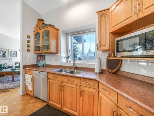 Well-lit kitchen featuring wood cabinetry, a dual basin sink, and a built-in microwave - 308 Beringer Crescent, Edmonton, AB - Indoor Photo Showing Kitchen With Double Sink