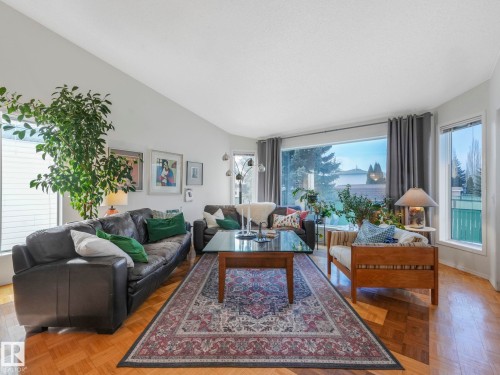 Living room featuring hardwood floors, a vaulted ceiling, and bay windows providing natural light - 308 Beringer Crescent, Edmonton, AB - Indoor Photo Showing Living Room
