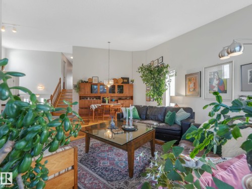Spacious living area featuring light-colored walls, a wooden staircase with white risers, and hardwood flooring - 308 Beringer Crescent, Edmonton, AB - Indoor Photo Showing Living Room