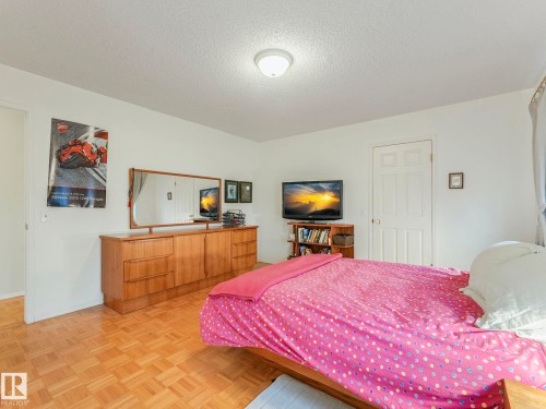 This room features light-colored walls and a parquet wood floor - 308 Beringer Crescent, Edmonton, AB - Indoor Photo Showing Bedroom