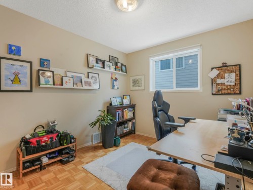 This room features light-colored walls and patterned wood flooring, offering a versatile space - 308 Beringer Crescent, Edmonton, AB - Indoor Photo Showing Office