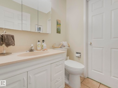 The bathroom features a vanity with a light-colored countertop and white cabinetry, a built-in sink, and a mirrored medicine cabinet above - 308 Beringer Crescent, Edmonton, AB - Indoor Photo Showing Bathroom
