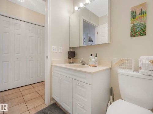 Bathroom featuring a vanity with a white countertop and white cabinetry, a mirror with integrated lighting, and a toilet - 308 Beringer Crescent, Edmonton, AB - Indoor Photo Showing Bathroom