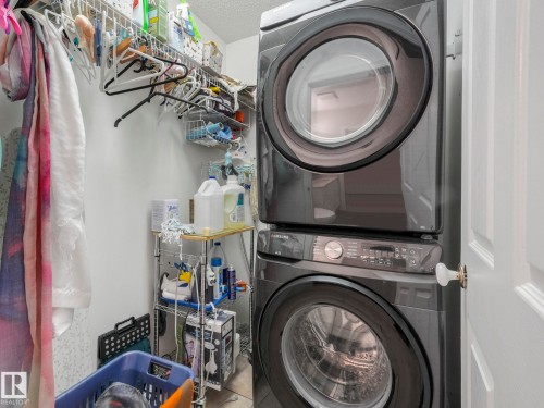Dedicated laundry area featuring a stacked washer and dryer unit - 308 Beringer Crescent, Edmonton, AB - Indoor Photo Showing Laundry Room